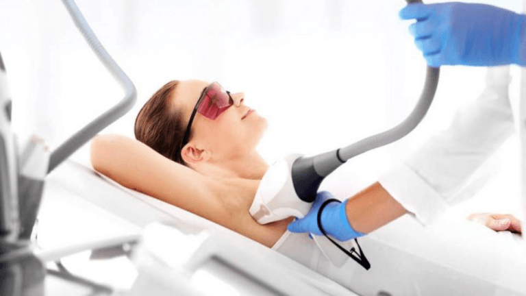Женщина проходит лазерную терапию, лежа в стоматологическом кресле и надев защитные очки.