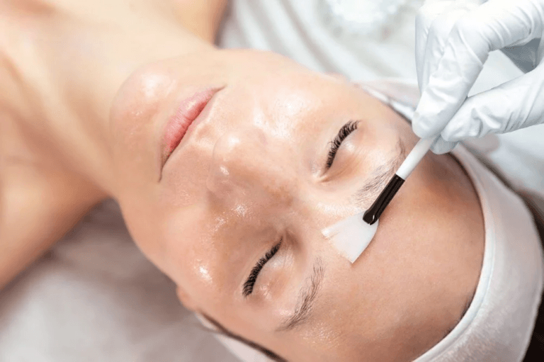 A woman receiving a facial treatment with a cotton swab, likely in a clinical or spa setting.