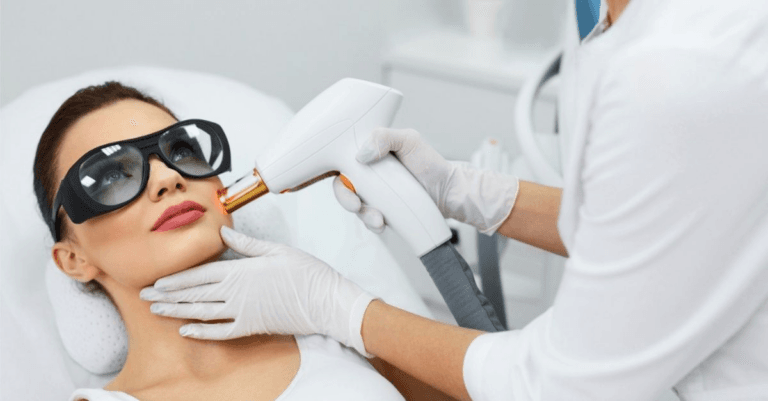 A woman receiving a laser treatment on her face from a professional wearing protective gear.